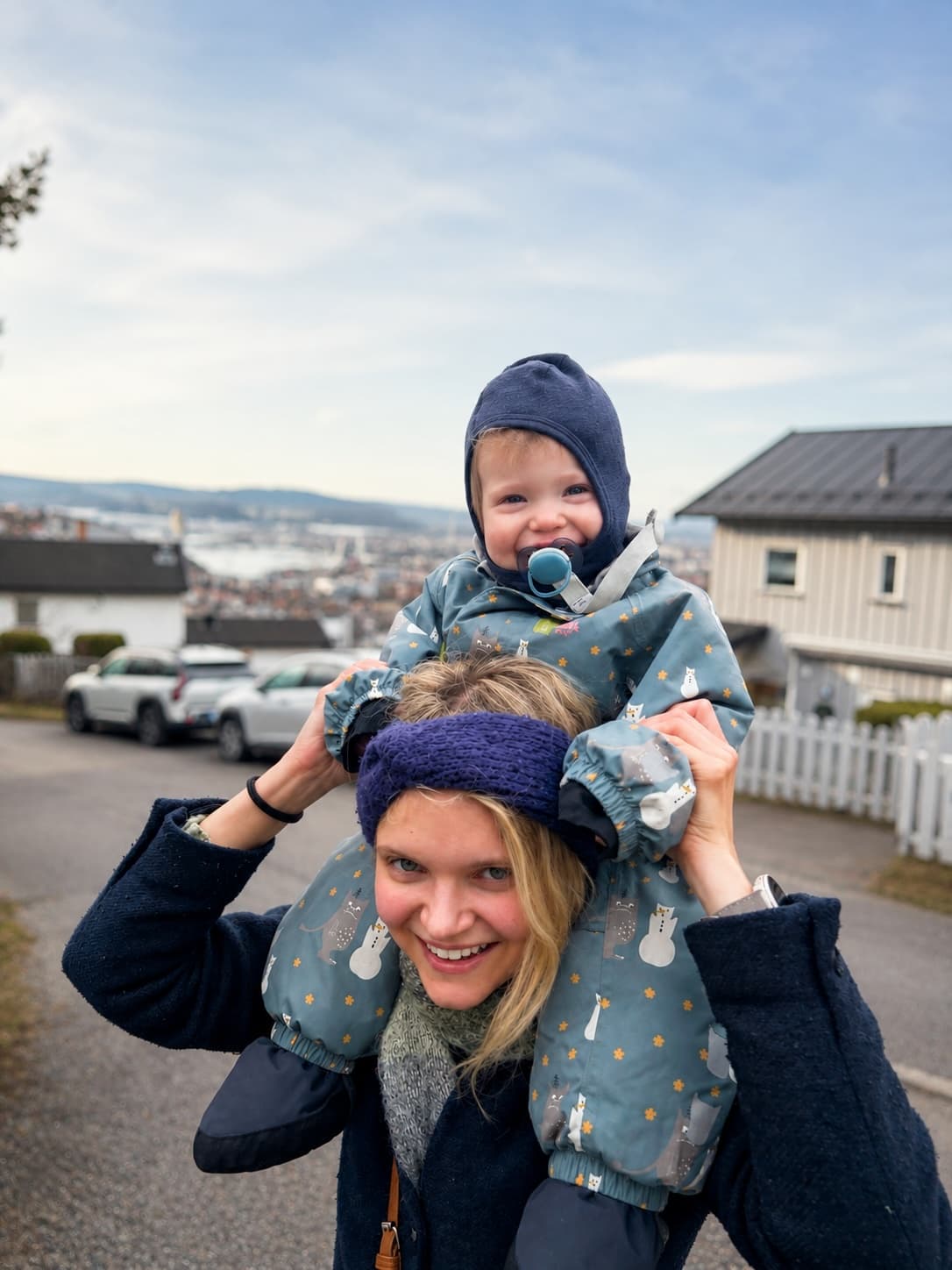 Malin med barnet sitt på skuldrene, med utsikt over Oslo i bakgrunnen.